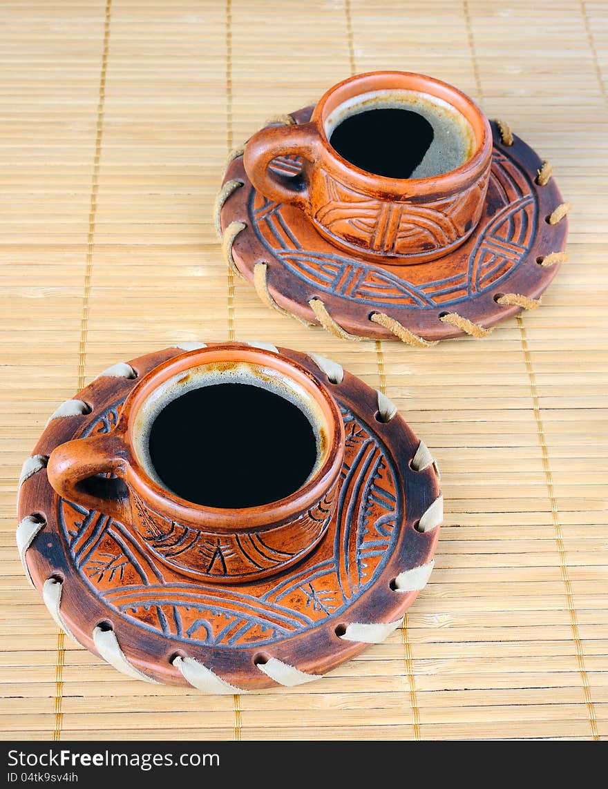 Two cups of coffee on a mat