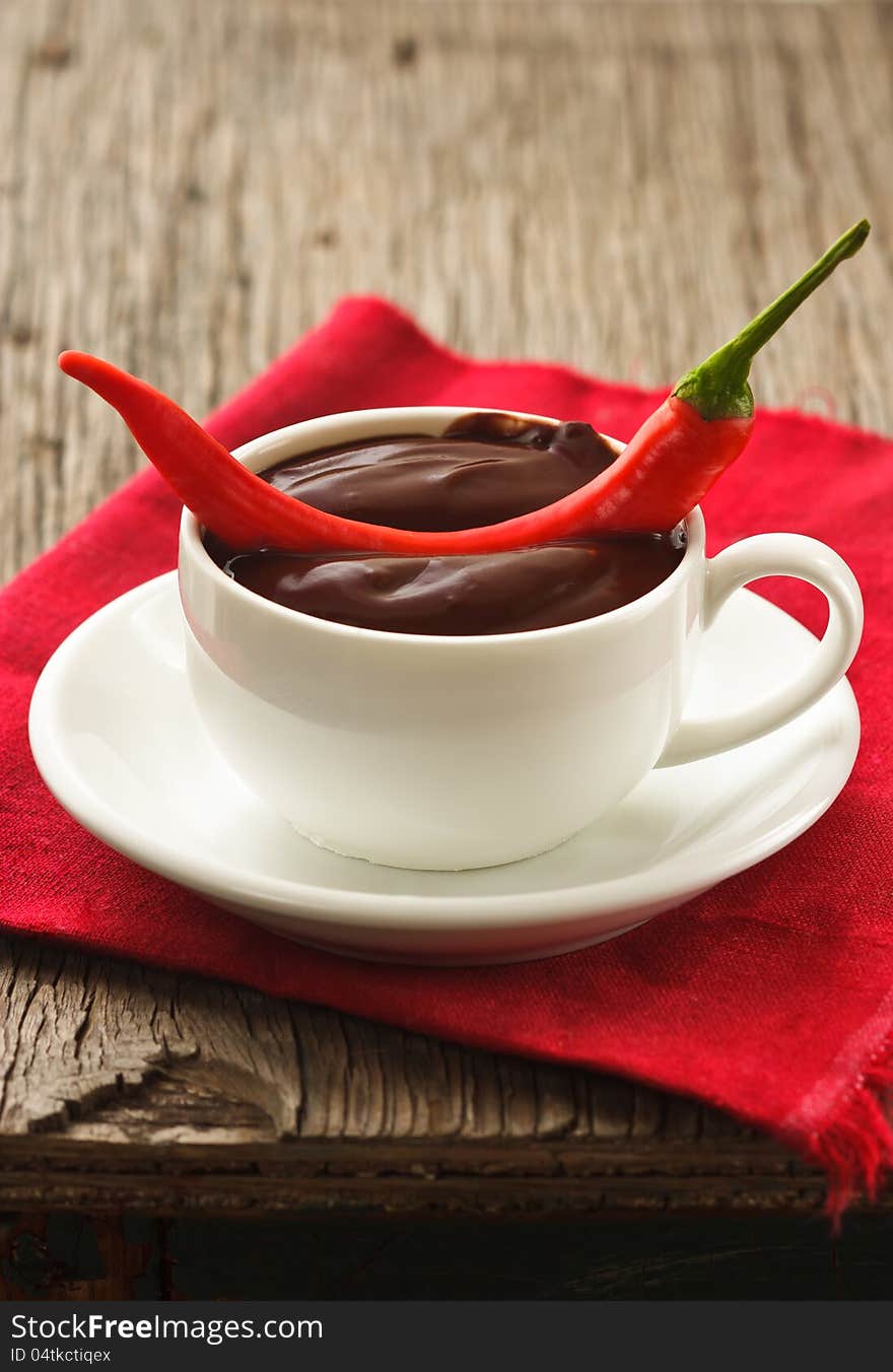 Hot chocolate with chili on an old wooden table. Hot chocolate with chili on an old wooden table.