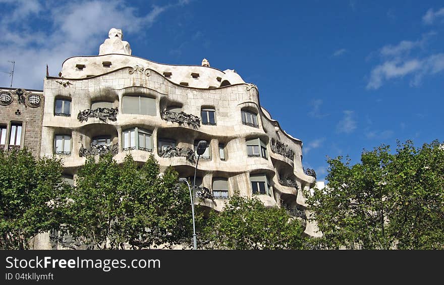 Mila house, designed by Gaudì in Barcelona, external view of the upper part above the treetops. Mila house, designed by Gaudì in Barcelona, external view of the upper part above the treetops