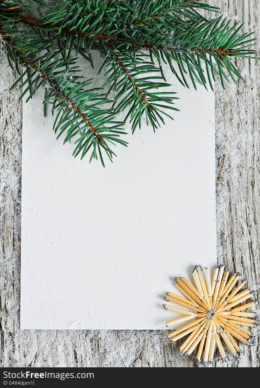 Christmas card with firtree branch on the old wood background