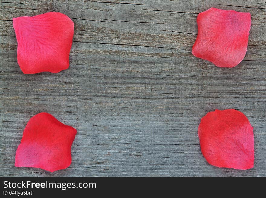 Rose petals on the wooden texture. Close-up.