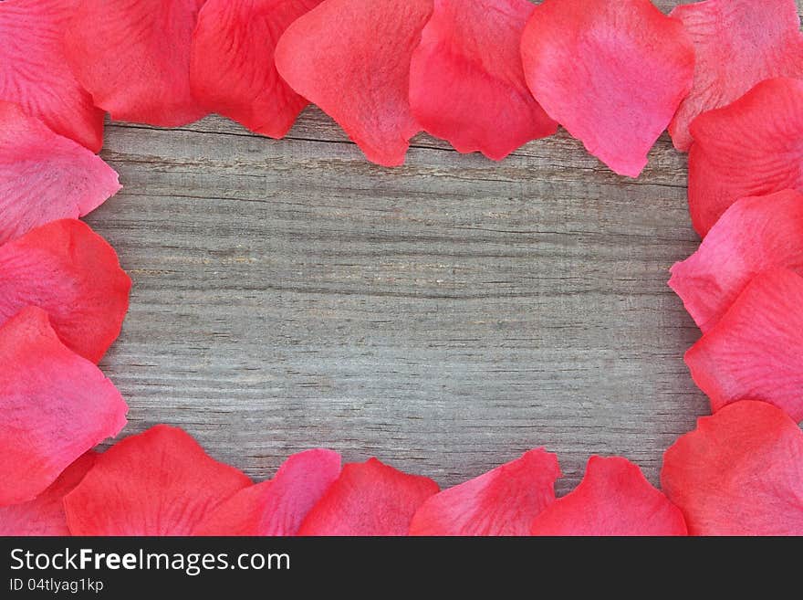 Rose petals on textured wood. Closeup.