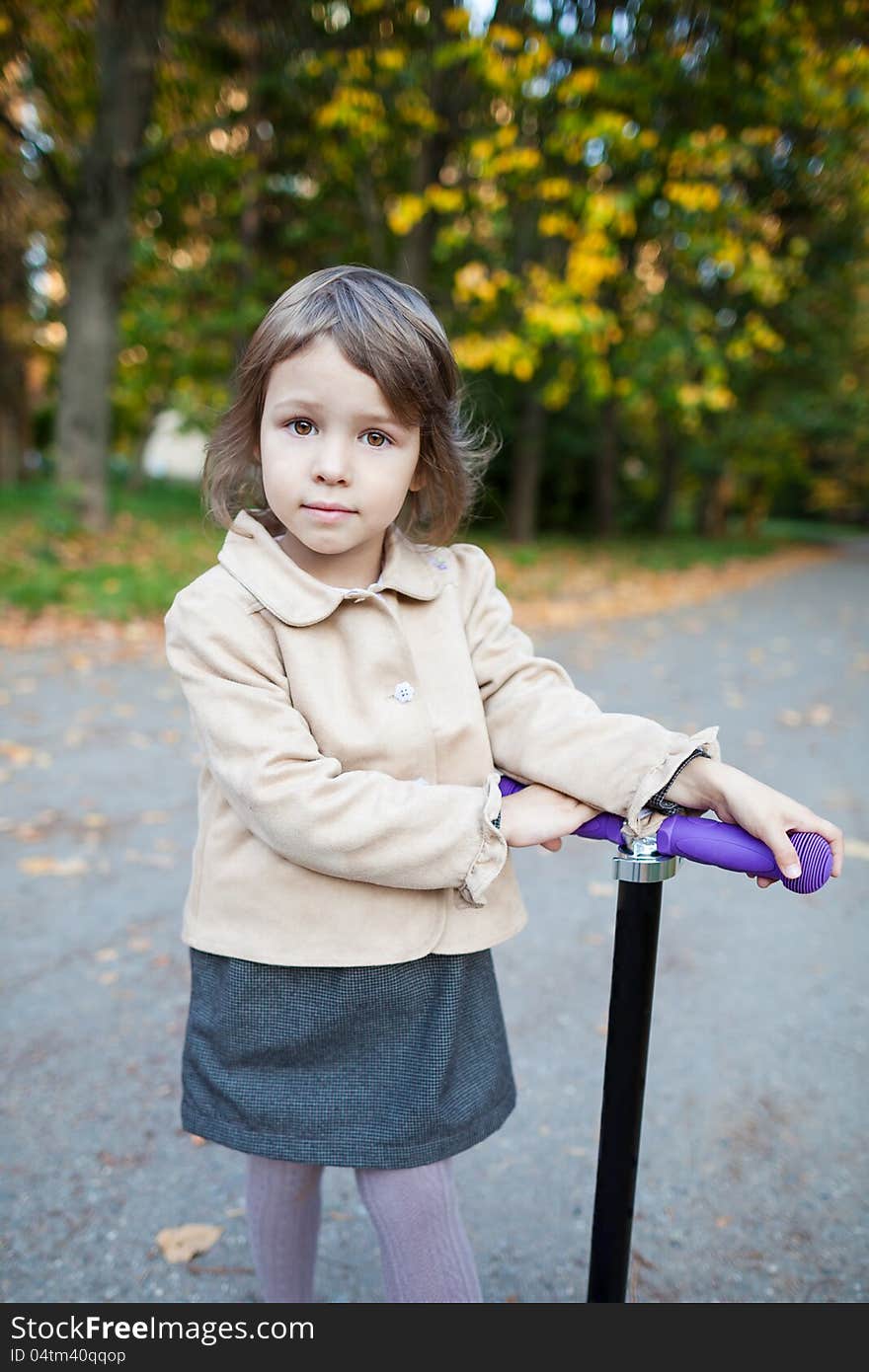 Preschooler Girl Outdoor In The Park With Scooter