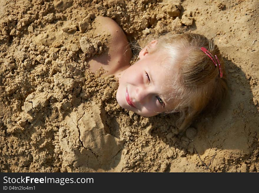 Little girl lying on sand