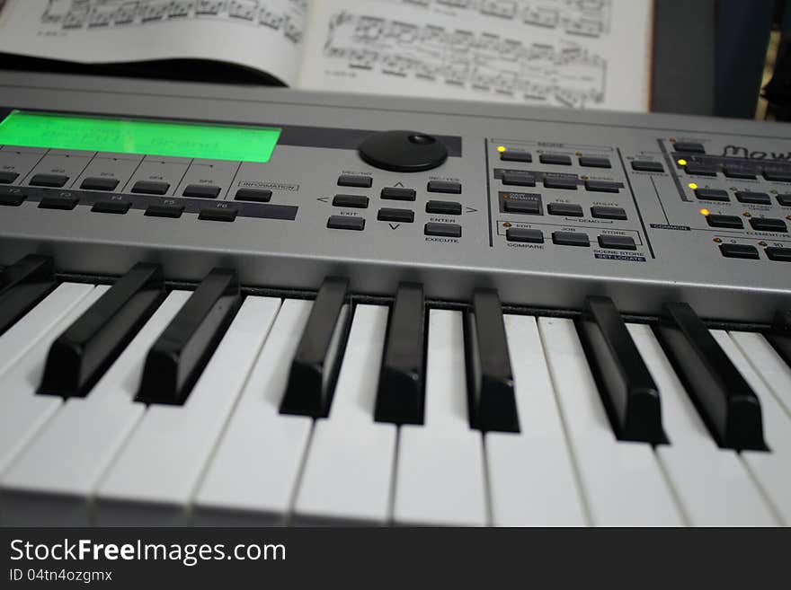 Synthesizer and music on a stand behind the keyboard. Synthesizer and music on a stand behind the keyboard