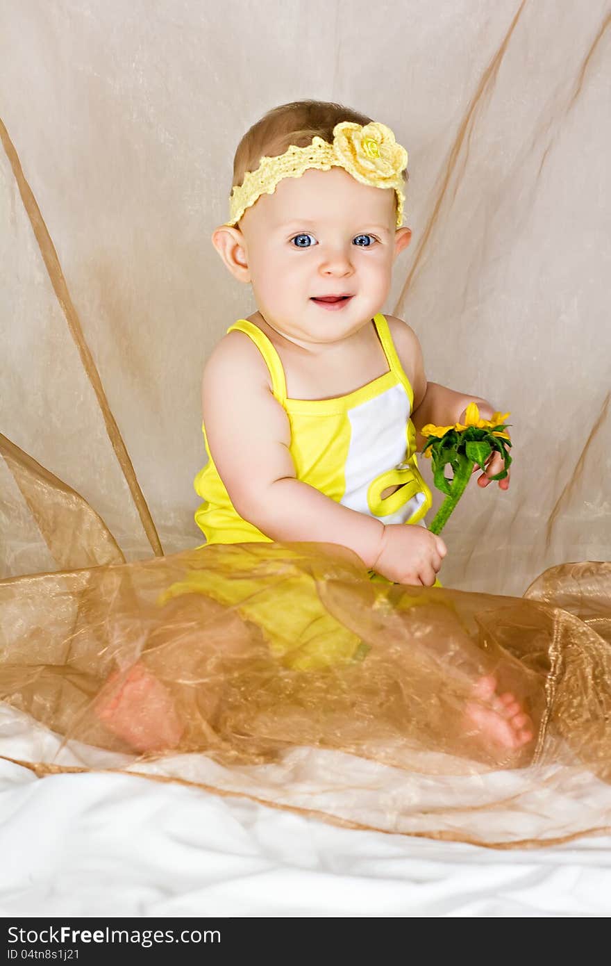 Beautiful little girl smiles and sits with yellow flower. Beautiful little girl smiles and sits with yellow flower