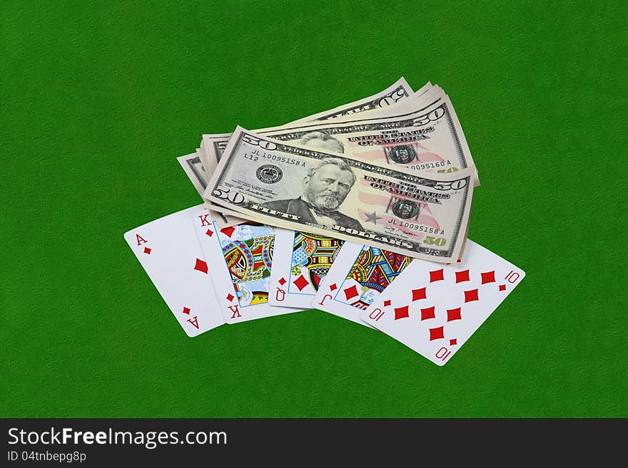 Royal flush combination and thousand of US dollars on green cloth table. Royal flush combination and thousand of US dollars on green cloth table