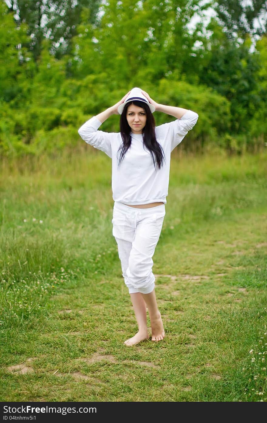 A young girl standing in the green grass area. A young girl standing in the green grass area