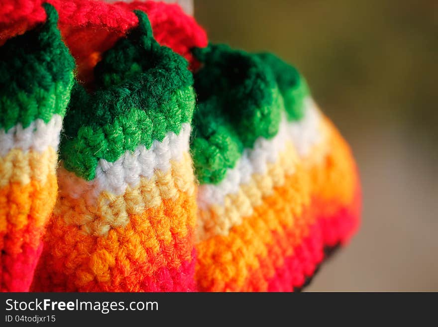 Beautiful multicolored handwoven woolen dress closeup photo. The colors of the cloth include red, orange, yellow, green and pink. Beautiful multicolored handwoven woolen dress closeup photo. The colors of the cloth include red, orange, yellow, green and pink.