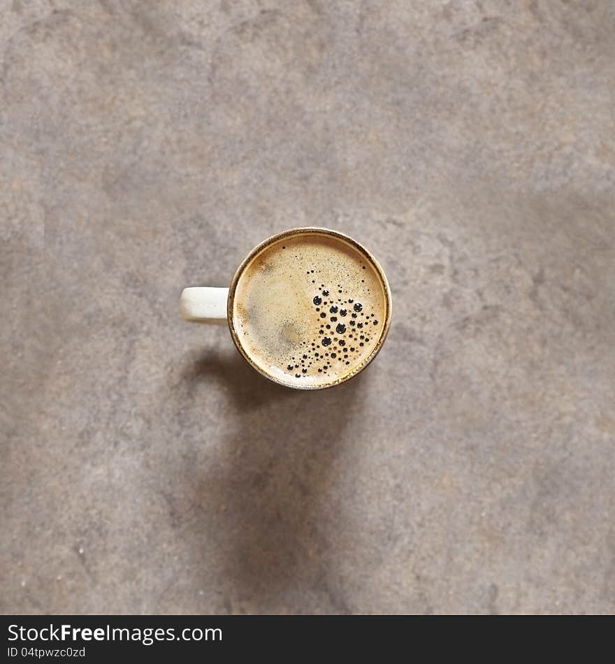 From directly above of a fresh black coffee. Natural light and tripod used for this image. The background is ceramic out of focus (just enough)