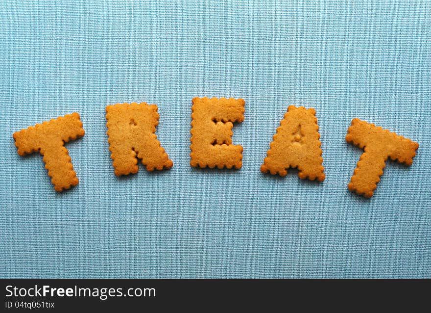 Word 'treat' spelled out with individual freshly baked sugar cookie characters