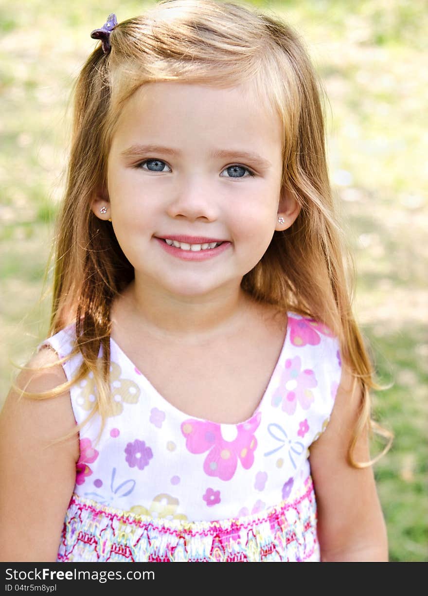 Outdoor portrait of cute little girl on the meadow