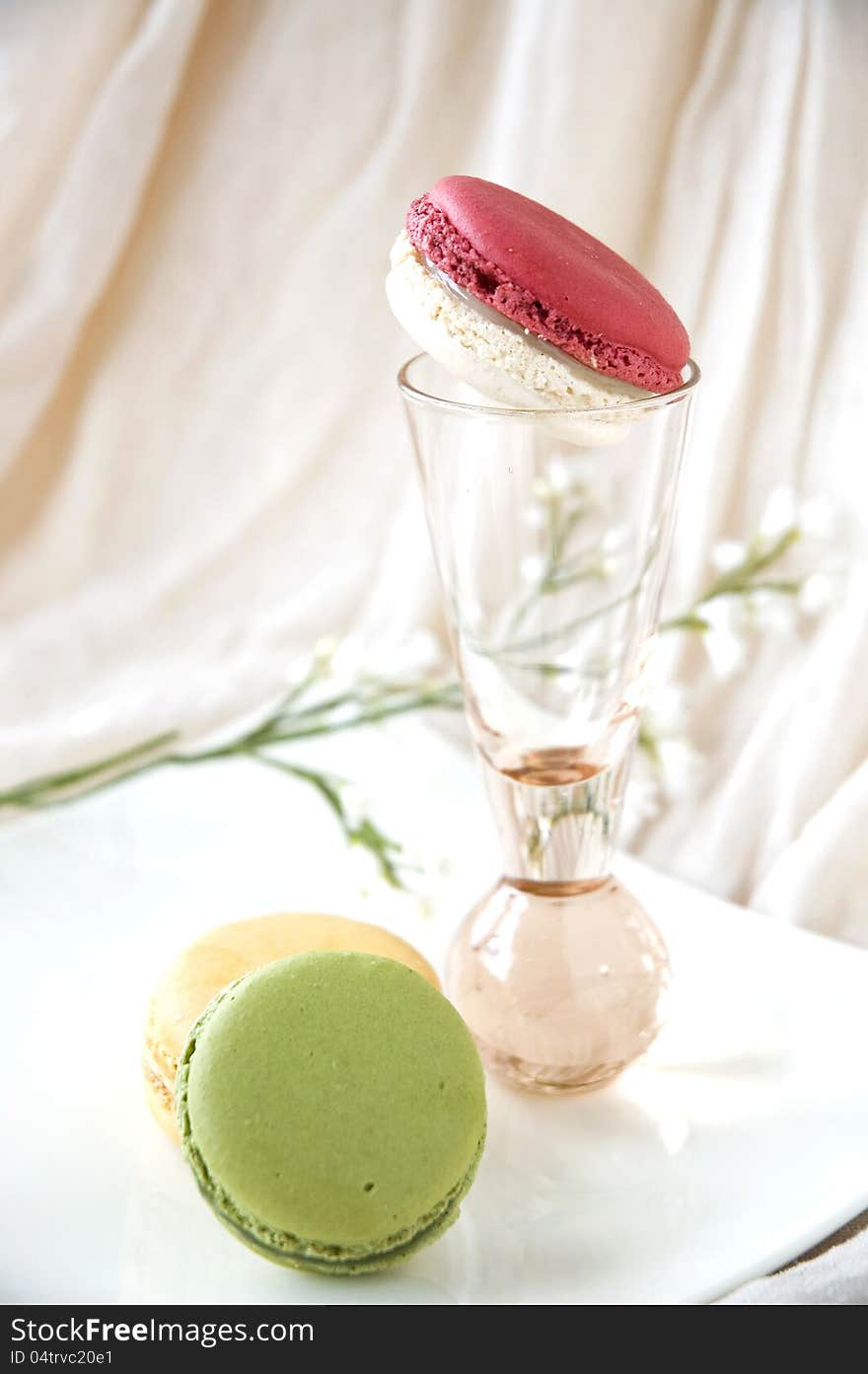 Macarons serve on white plate and pink glass. Macarons serve on white plate and pink glass