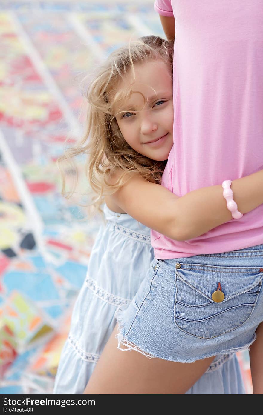 Pretty girl with her mother walking in the summer day