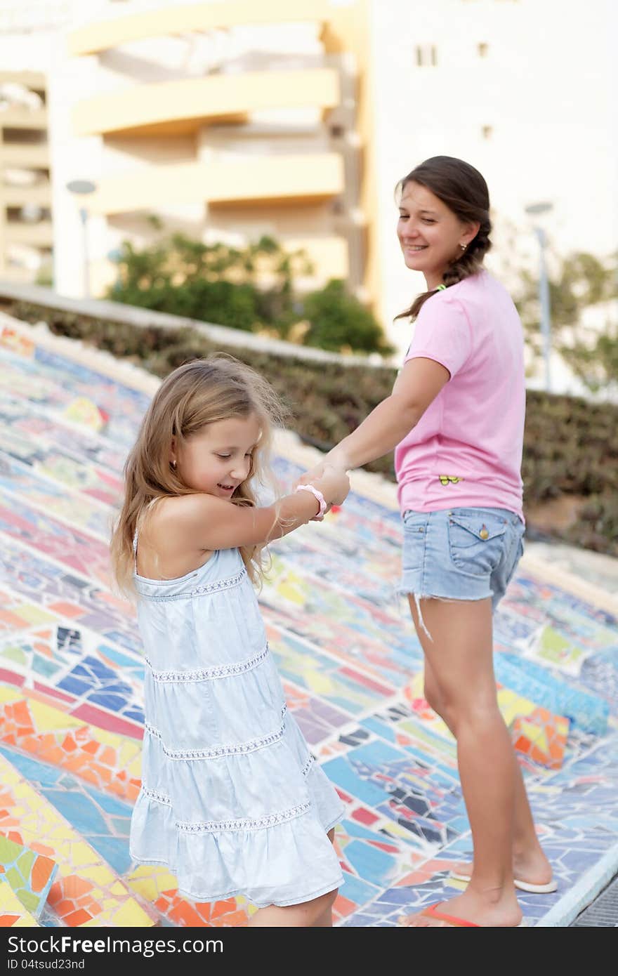 Pretty girl playing with her mother in the summer day