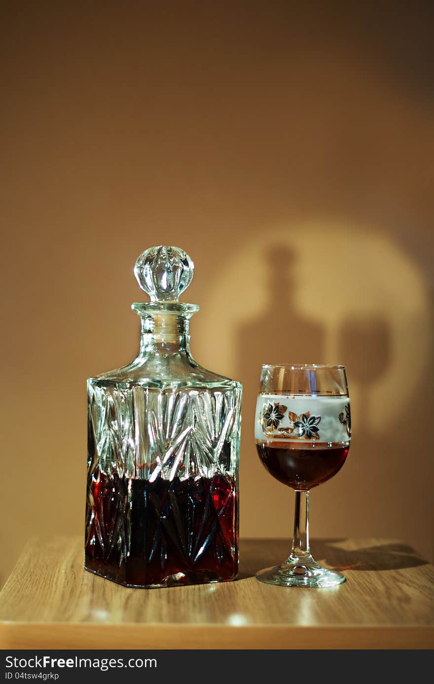 Crystal decanter with red wine and glass on the table. Crystal decanter with red wine and glass on the table