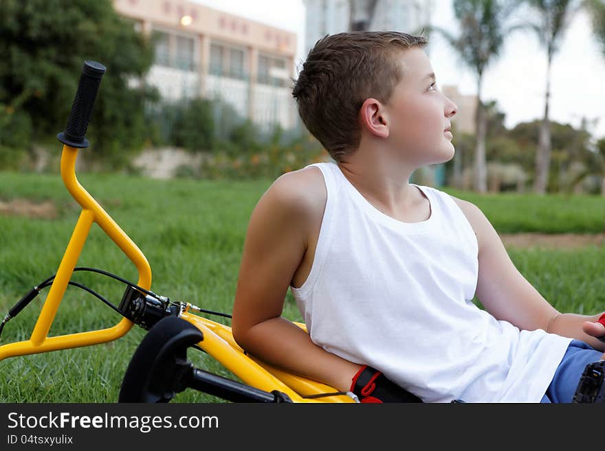 Boy with a bicycle outside in the summer day