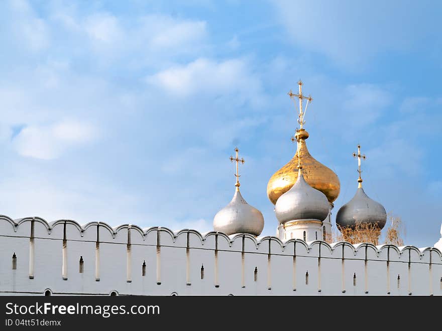 The cupolas of the Cathedral Cathedral of Our Lady of Smolensk behind the fortress wall of Novodevichy Convent, Moscow. The cupolas of the Cathedral Cathedral of Our Lady of Smolensk behind the fortress wall of Novodevichy Convent, Moscow