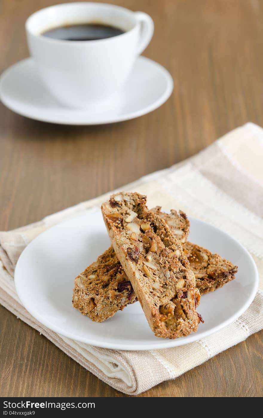 Biscotti cookies on a white plate and a cup of coffee. Biscotti cookies on a white plate and a cup of coffee