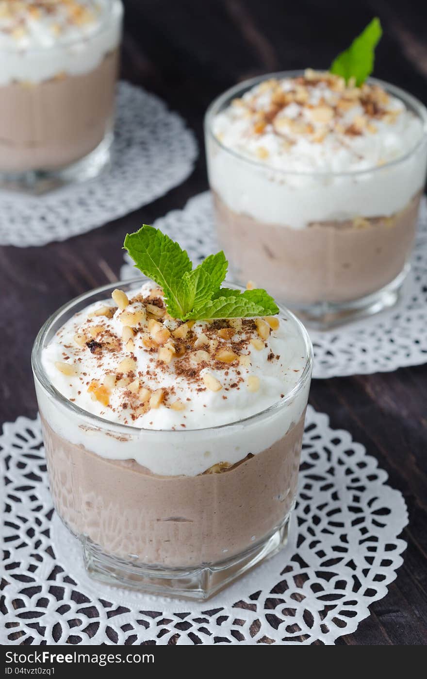 Chocolate dessert with whipped cream in a glass beaker closeup