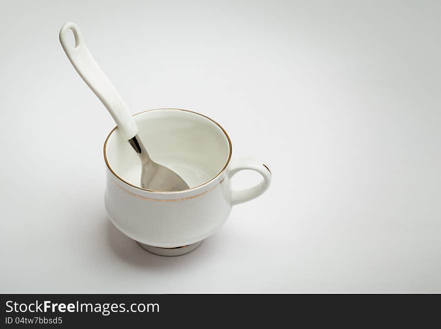 White cup and spoon isolated over white