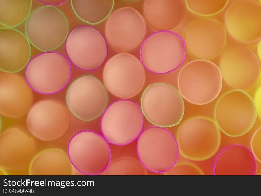 Brightly colored plastic tubes for drinks laid in the background. Brightly colored plastic tubes for drinks laid in the background