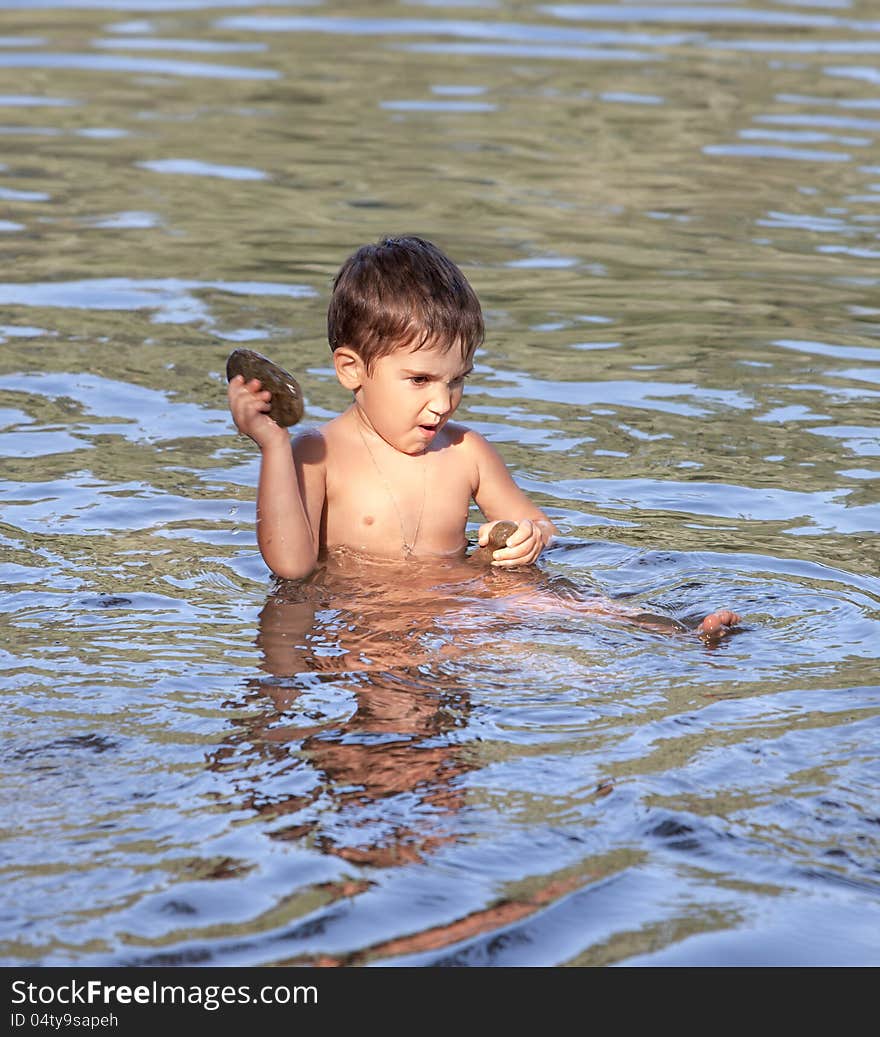 Little funny boy playing in water