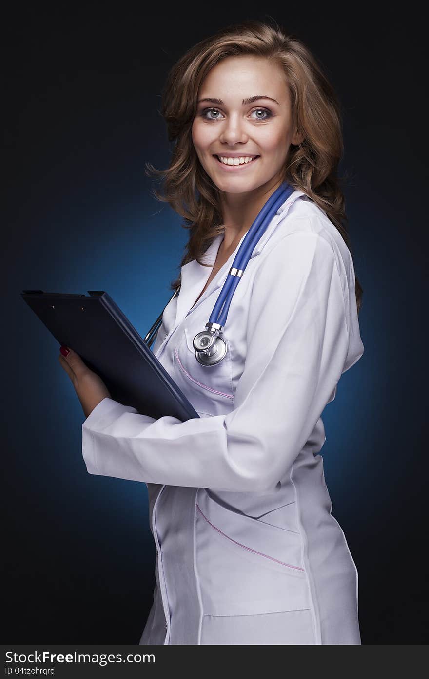 Young doctor woman with stethoscope on dark blue background