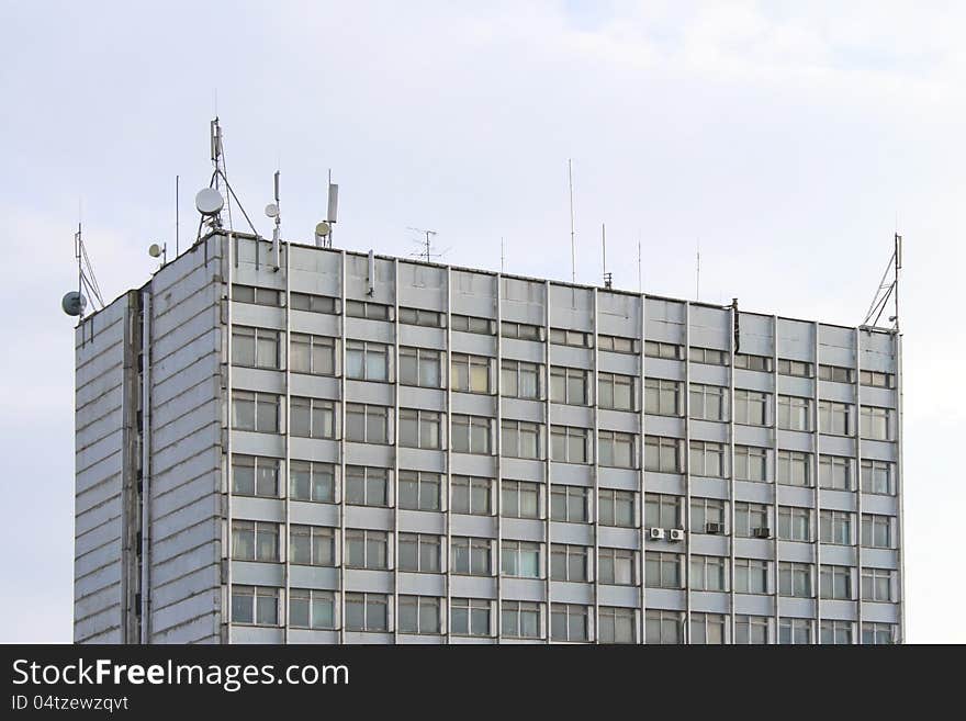 Photo of unusual research building from glass and iron with every possible aerials against sky. Photo of unusual research building from glass and iron with every possible aerials against sky