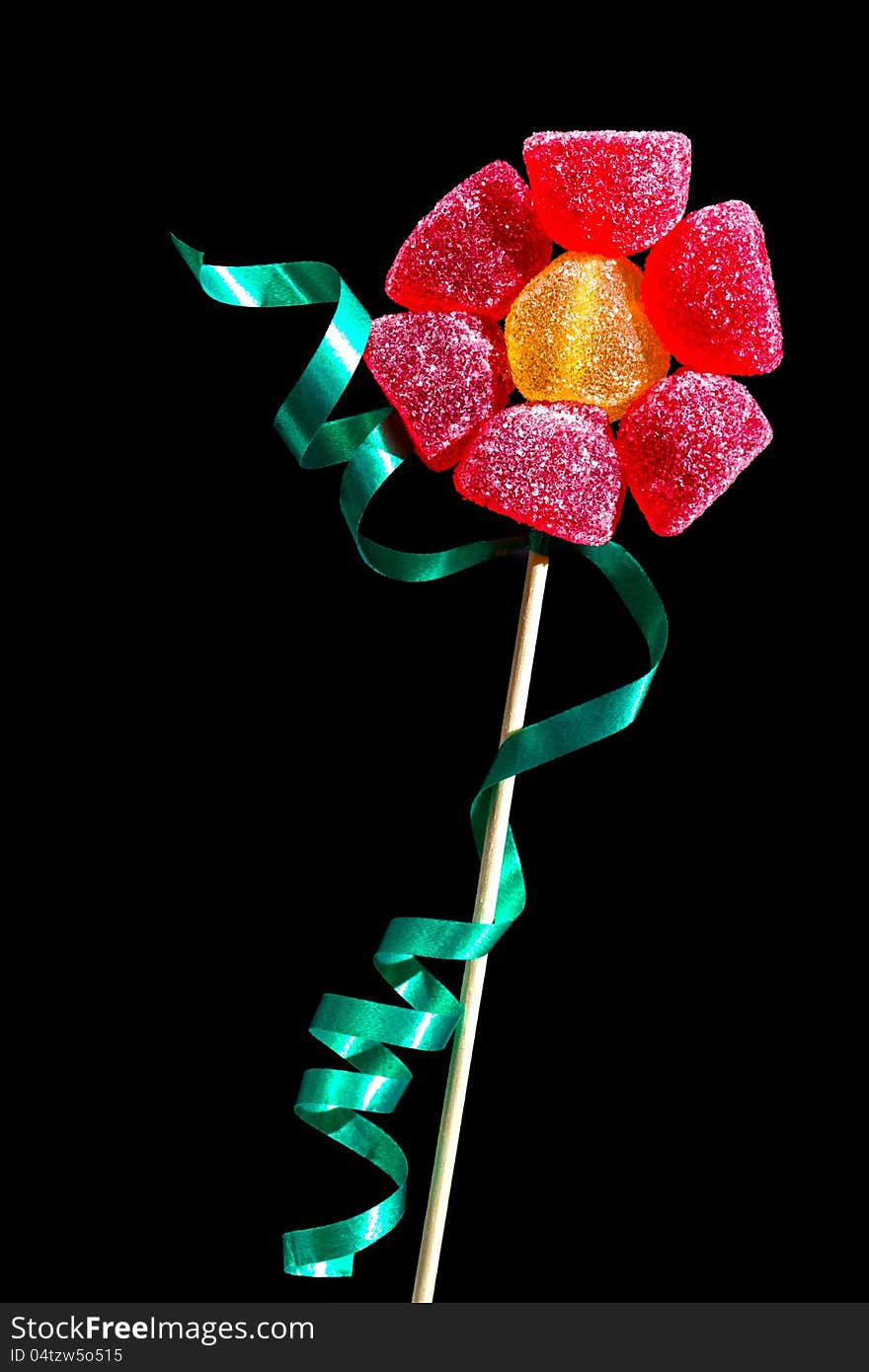 Flower made of gumdrops on a stick with a green ribbon. Flower made of gumdrops on a stick with a green ribbon