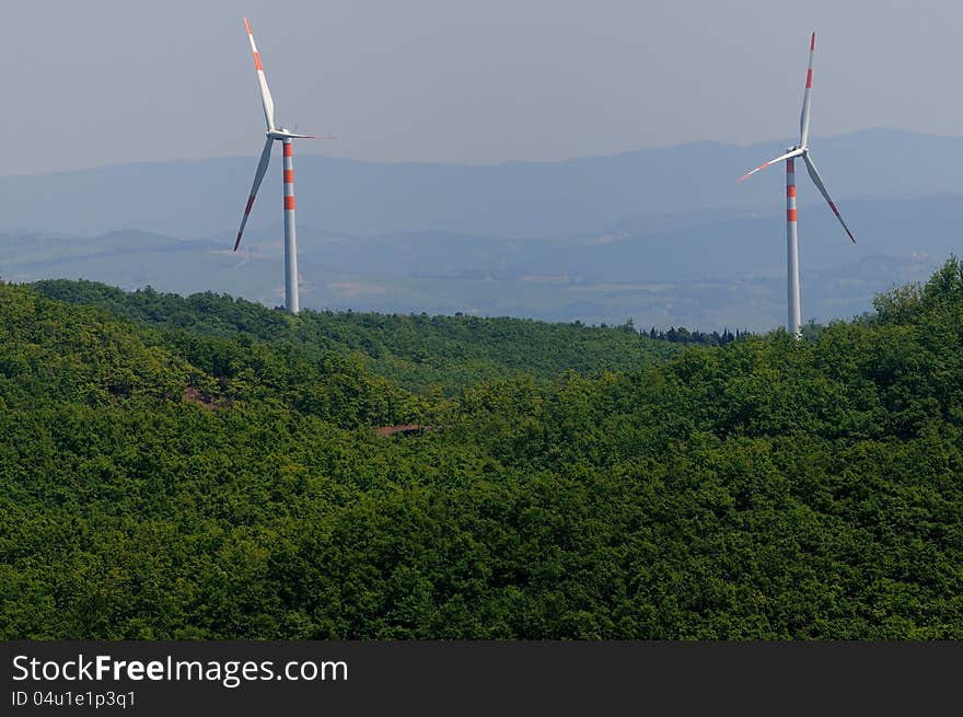 Two wind turbines on a green hill. Two wind turbines on a green hill