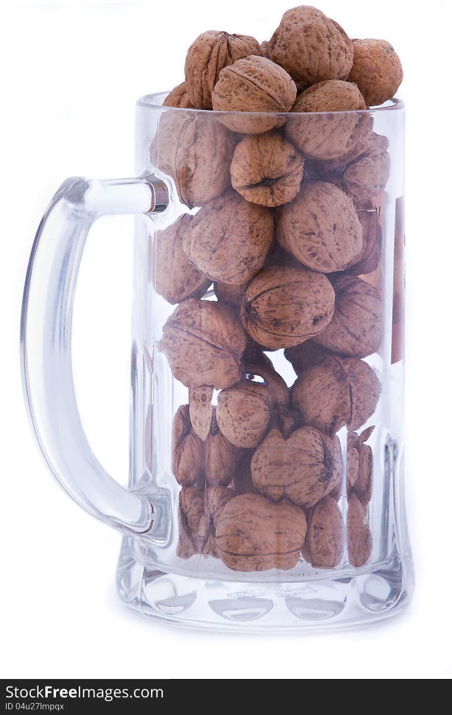 Transparent mug filled with walnuts. Transparent mug filled with walnuts