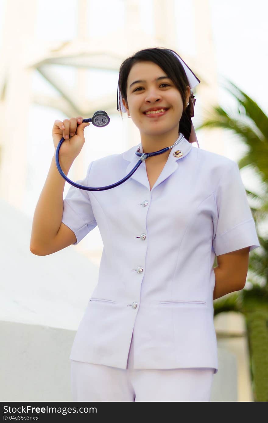 Nurse smiling with stethoscope in the garden