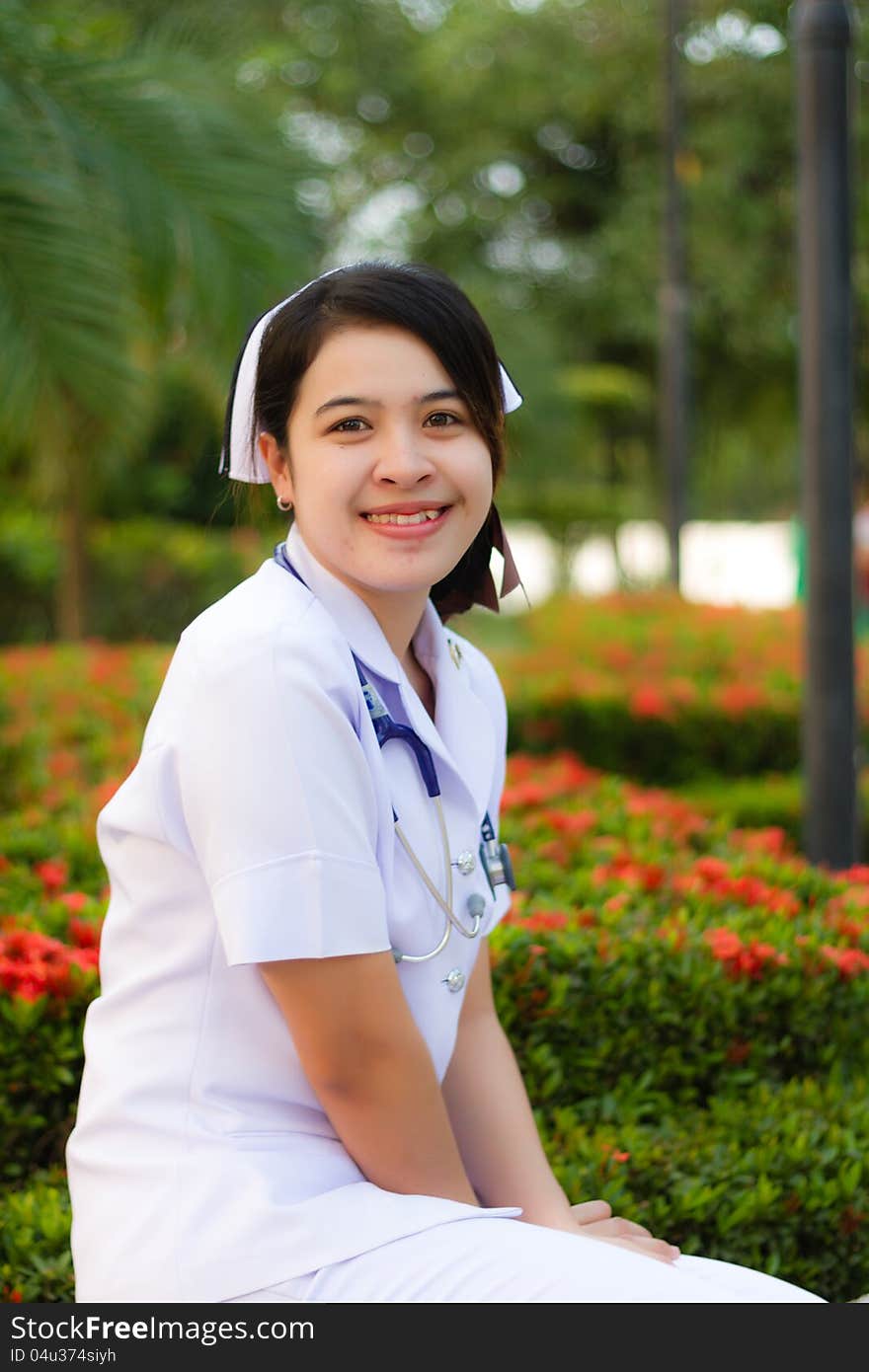 Thai nurse smiling with stethoscope in the garden