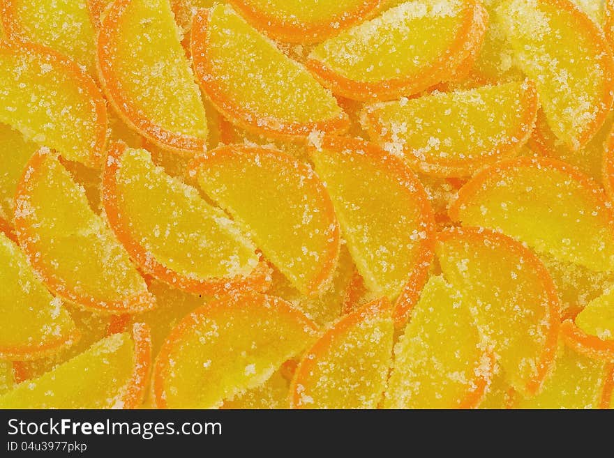 Yellow marmalade imitating orange slices with sugar background