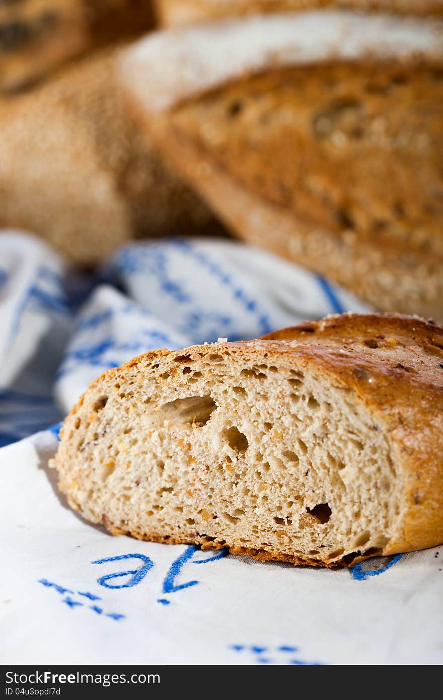 Baked bread sliced, detail. Other breads in background blur