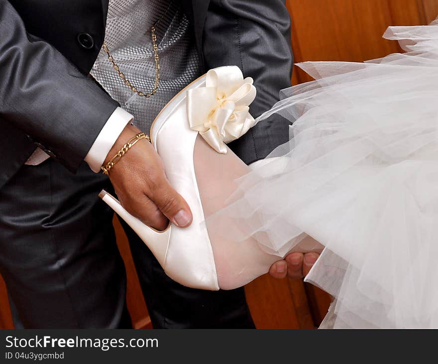 Father helps the bride putting on her shoe. Father helps the bride putting on her shoe.