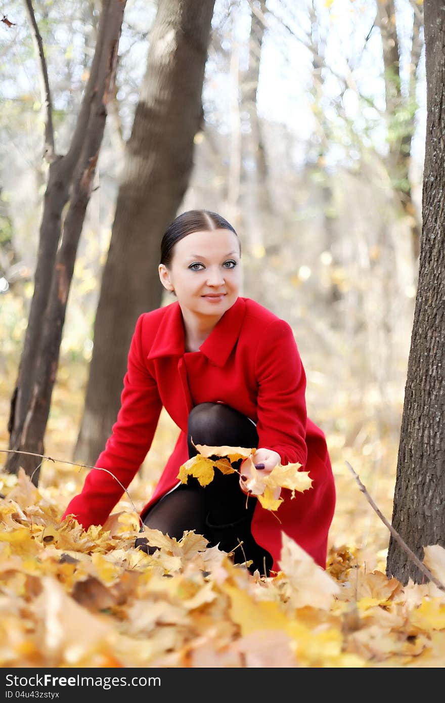 Pretty girl in red coat autumn day