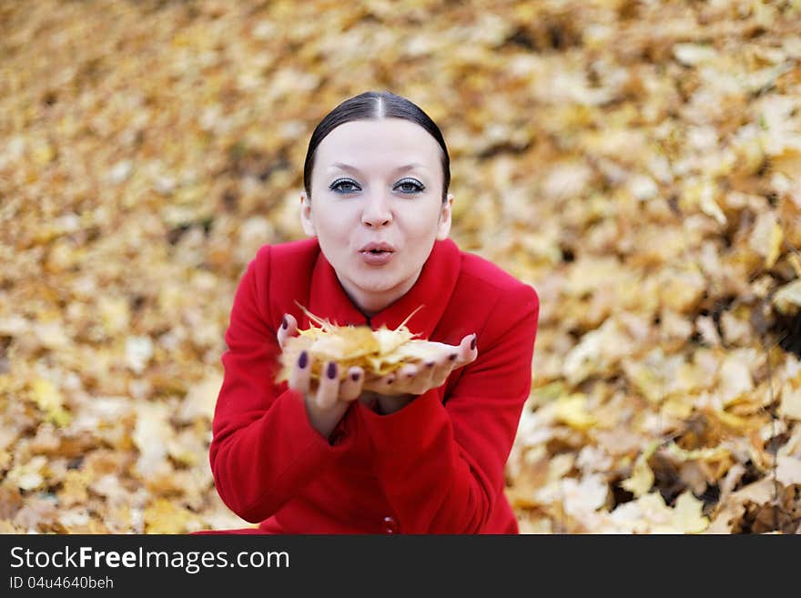 Cute girl in red coat with leaves