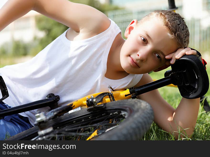 Boy rests with the bike in the park day