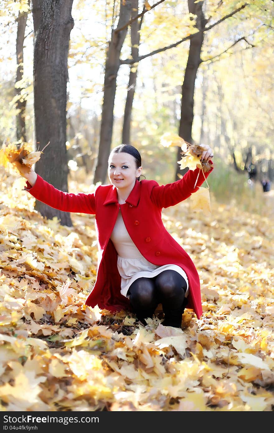 Happy girl playing with autumn leaves