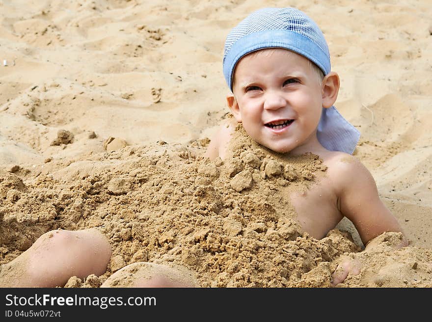 Little boy lying on the sand