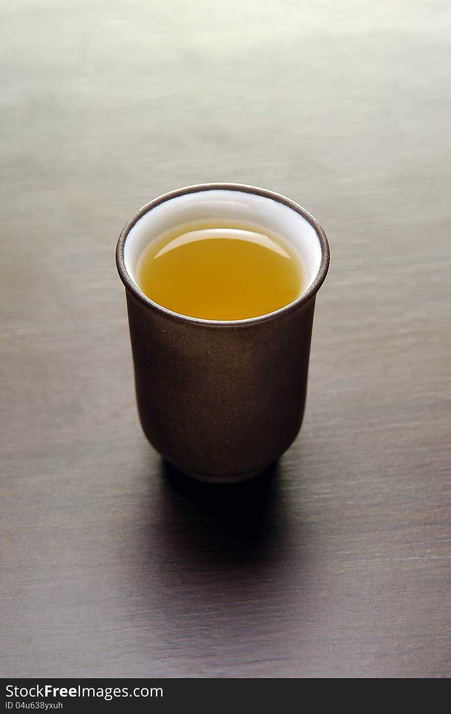 Two chinese tea cups on wooden table with tea