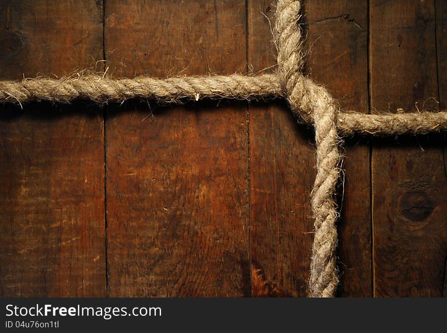 Knotted hemp rope on dark wooden surface. Knotted hemp rope on dark wooden surface