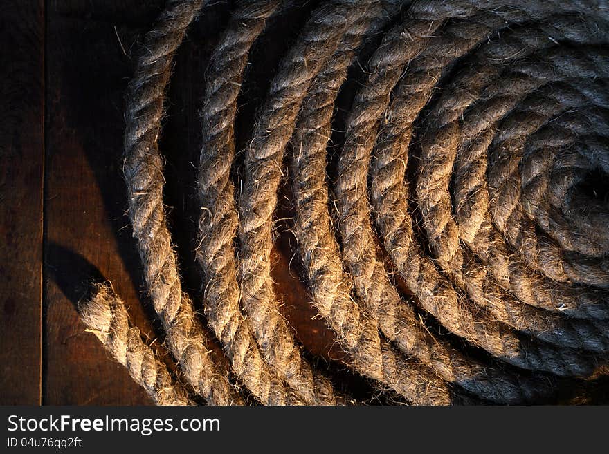 Skein of old hemp rope on dark wooden surface. Skein of old hemp rope on dark wooden surface