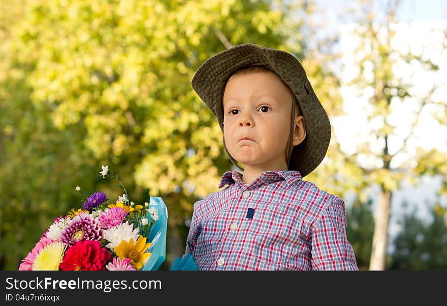 Bemused little boy with flowers