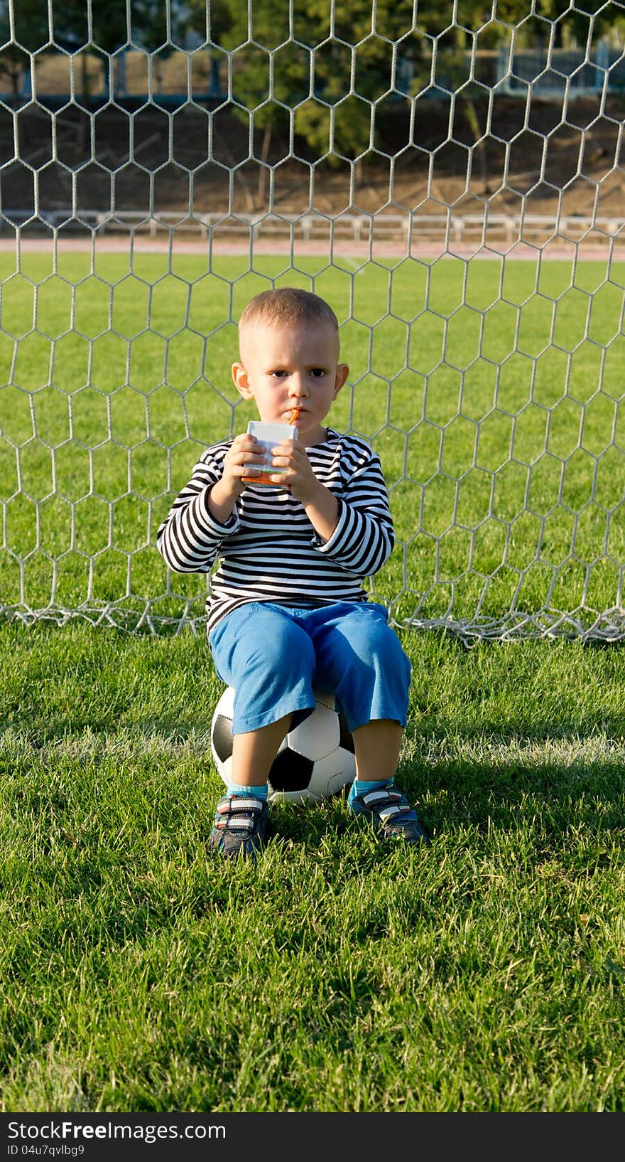 Little boy drinking while playing soccer