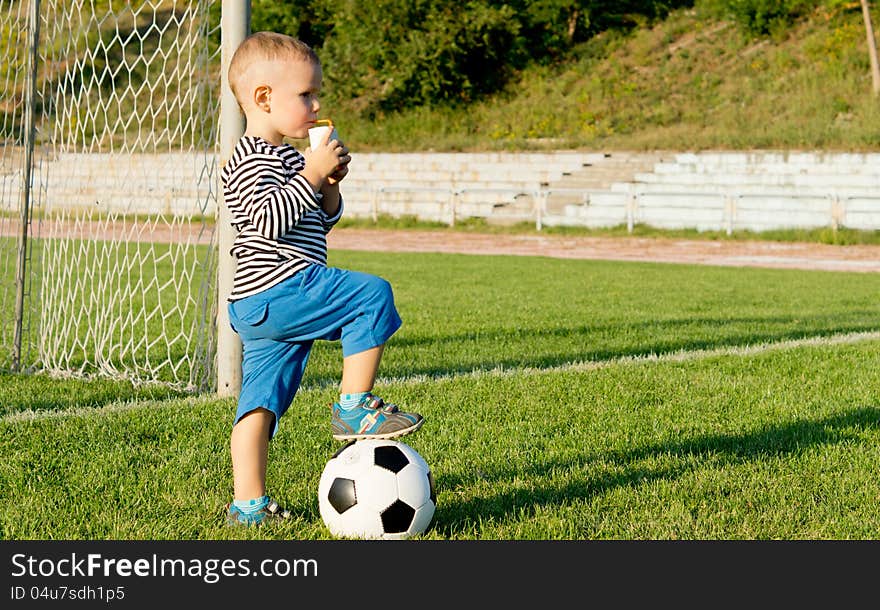 Little soccer player drinking juice