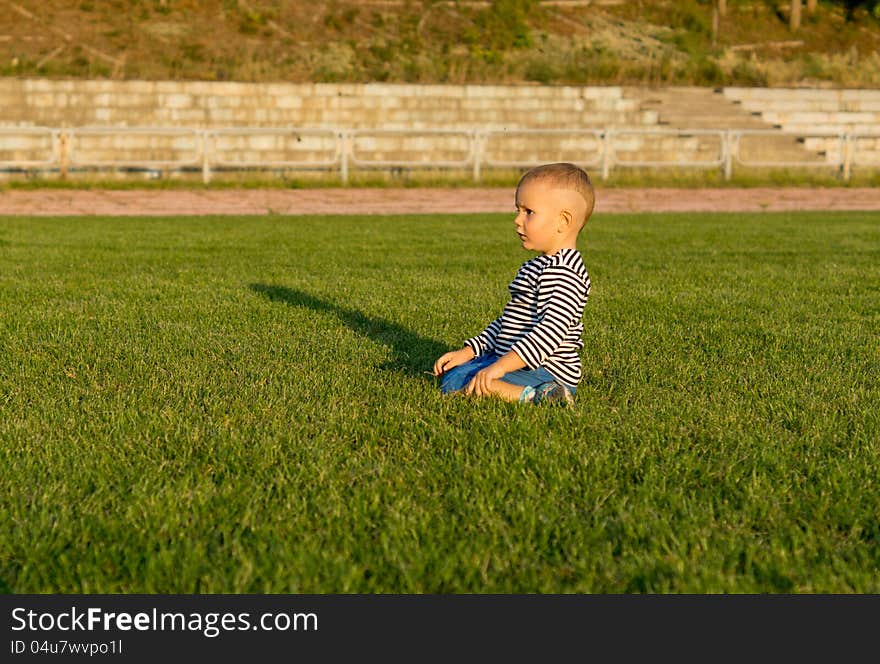 Small boy kneeling in green grass