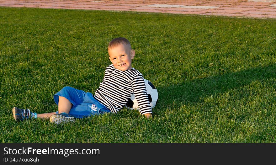 Small Boy Lying On Green Grass